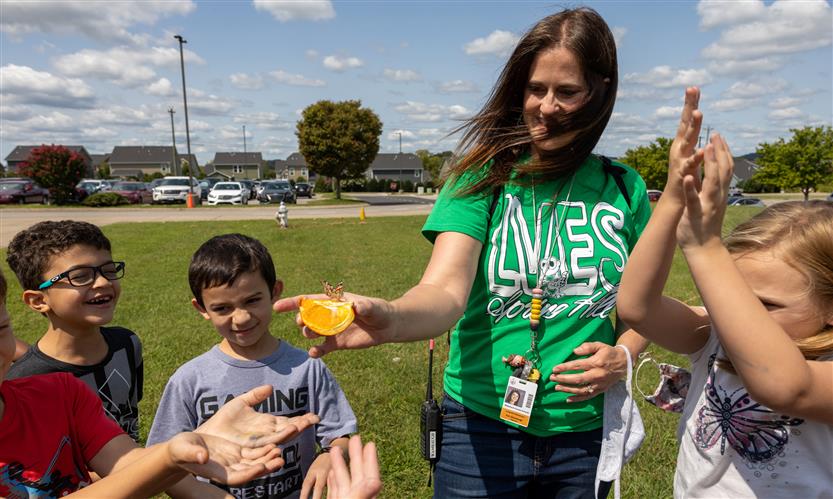 Students smile while releasing butterflies outside